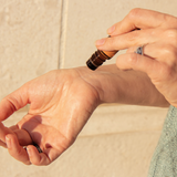 rolling essential oils on wrist using a roll on