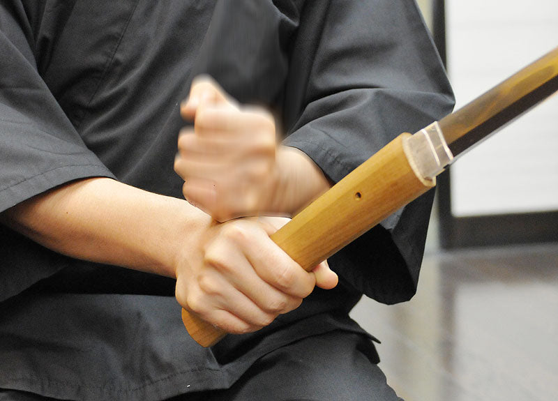 Image of right fist hitting your left wrist lightly a few times to remove the blade from Tsuka.
