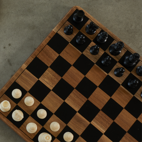 Wooden chess board with black and white chess pieces