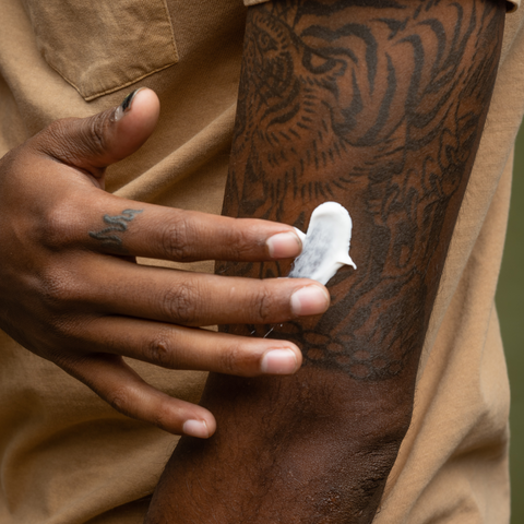 Person putting lotion on their arm