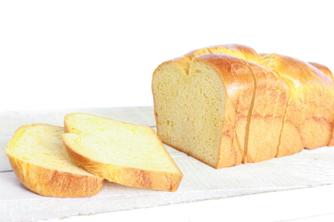 Brioche 500g pur beurre sur une planche avec 2 tranches tombées