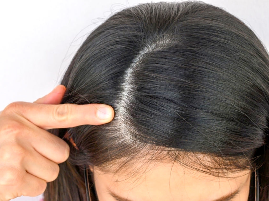 woman pointing to a part of her hair