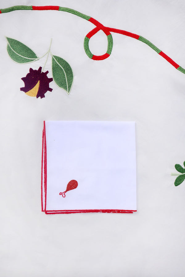 This napkin has a small brown turkey/chicken drumstick embroidered in the corner.  | © Pangea 2024