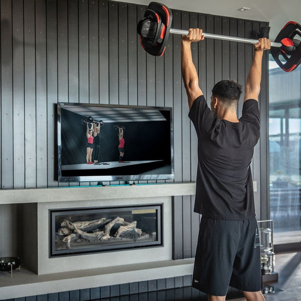 Man performing Les Mills plus exercise in his house