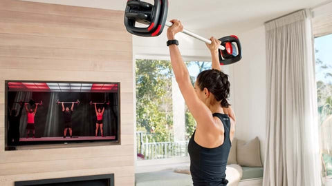 Woman doing a weight exercise with Les Mills SMARTTECH equipment 