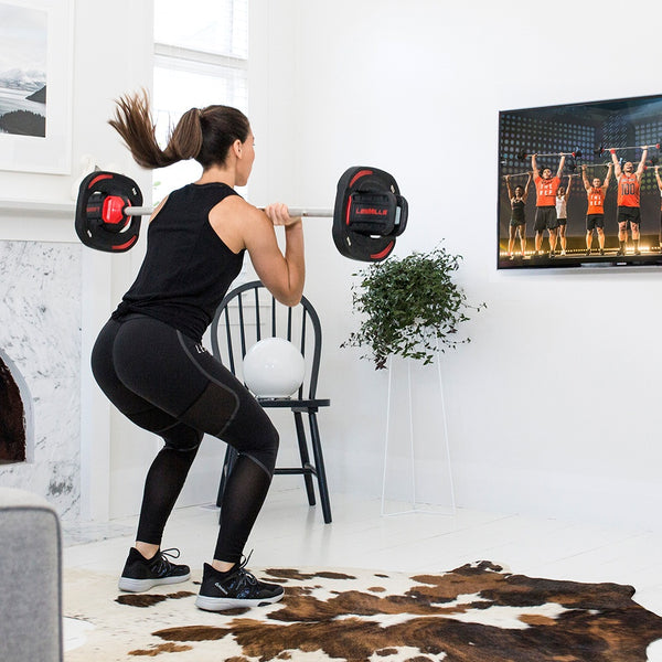 Woman doing the Les Mills Body Pump class at home