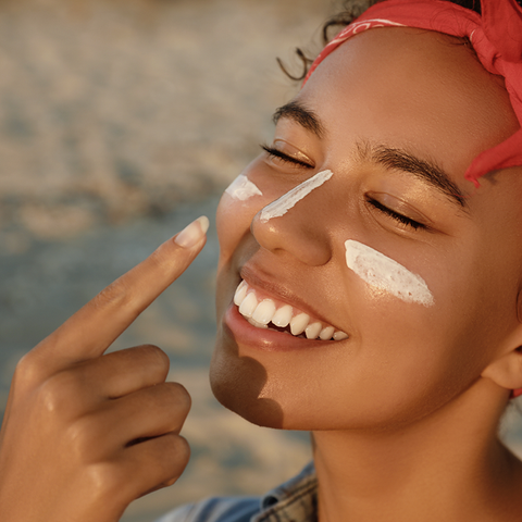 Woman applying sunscreen to face