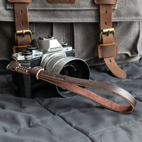 A Due North Leather Racer Camera Wrist Strap attached to an Olympus camera.