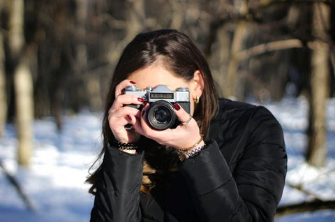 A woman shooting with her camera outdoors