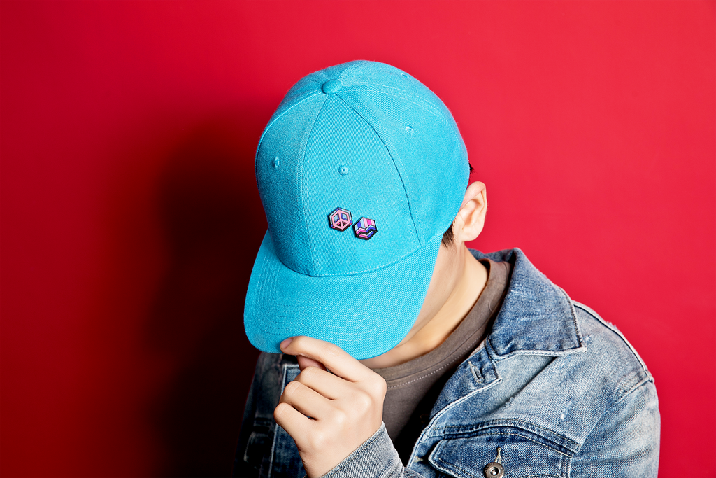 guy wearing hat with enamel pins on it