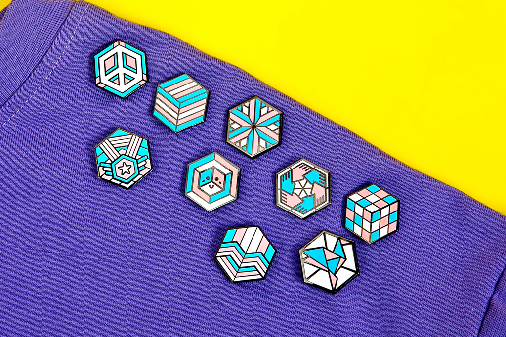9 trans flag pride pins on a purple shirt with yellow background