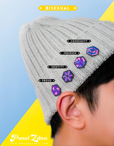 4 pride enamel pins on a beanie worn by a person with white and yellow background