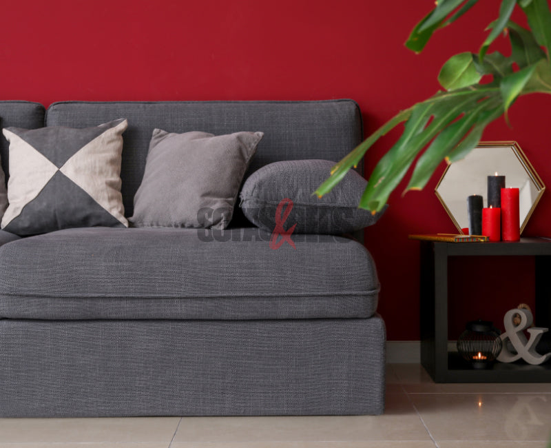 Grey sofa styled in a bright red coloured background | Sofas & Beds
