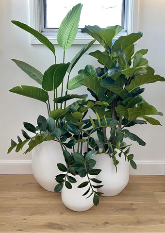 Three artificial plants with their white pots