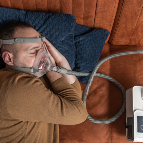 Man Sleeping While Using A Resmed Air Sense 10 CPAP Device