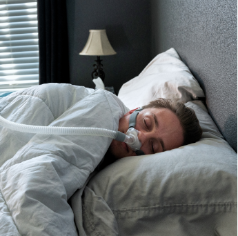Man Sleeping With Cpap Device and Cpap Mask Provided By The Sleep Institute