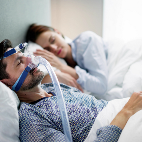 Man sleeping with CPAP device to prevent obstructive sleep apnea