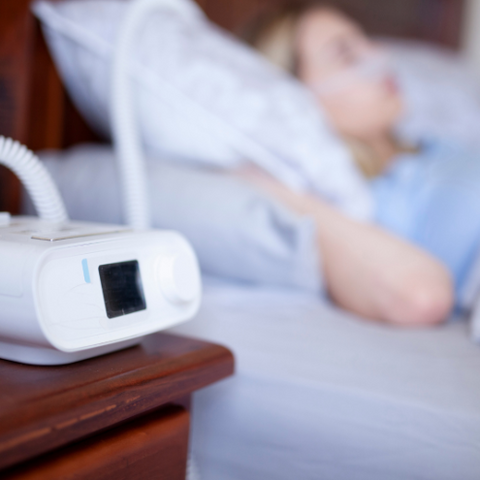 Woman sleeping with cpap device because she has obstructive sleep apnea