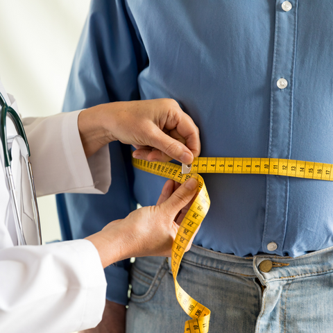 Man's stomach getting measured by doctor