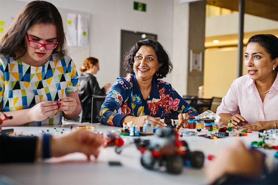 Manisha and participants on a co-design session, surrounded by lego on the table.