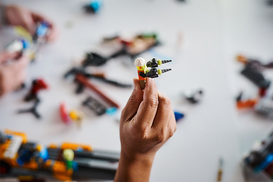 A hand holds up a lego figure