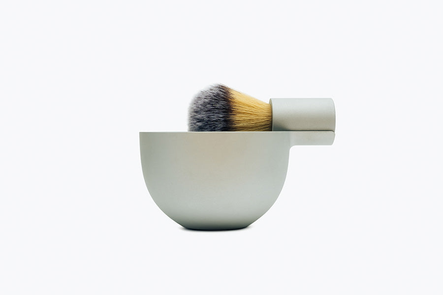 The brush and bowl by Morrama, forged from Al7075 aluminium. The minimal machined brush handle nestles perfectly in the arm of the bowl and holds a synthetic, cruelty free, brush knot ensuring it can drip dry after use.