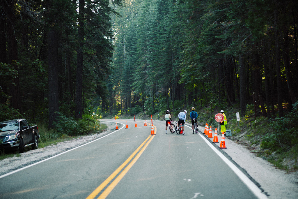 Dialed Health Everest Bike Riding Challenge with ALMSTHRE bike bags group riding bikes on road outside in trees