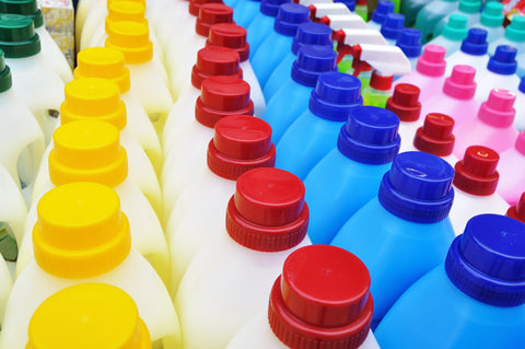 rows of plastic detergent bottles with different brightly coloured caps