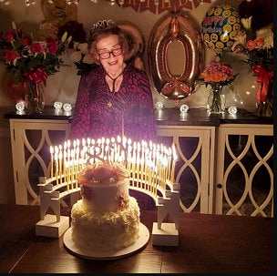 Mom's celebration 80 candles lit with a 3-tier birthday cake