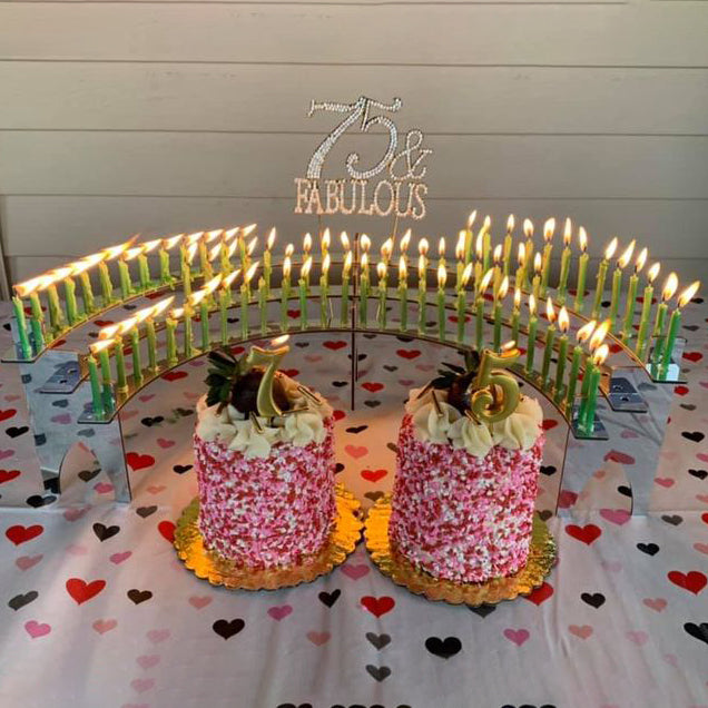 75th birthday party with two pretty cakes and 75 lit candles