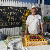 75th birthday party, rectangular birthday cake next to Celebration Stadium candle holder with 75 gold candles