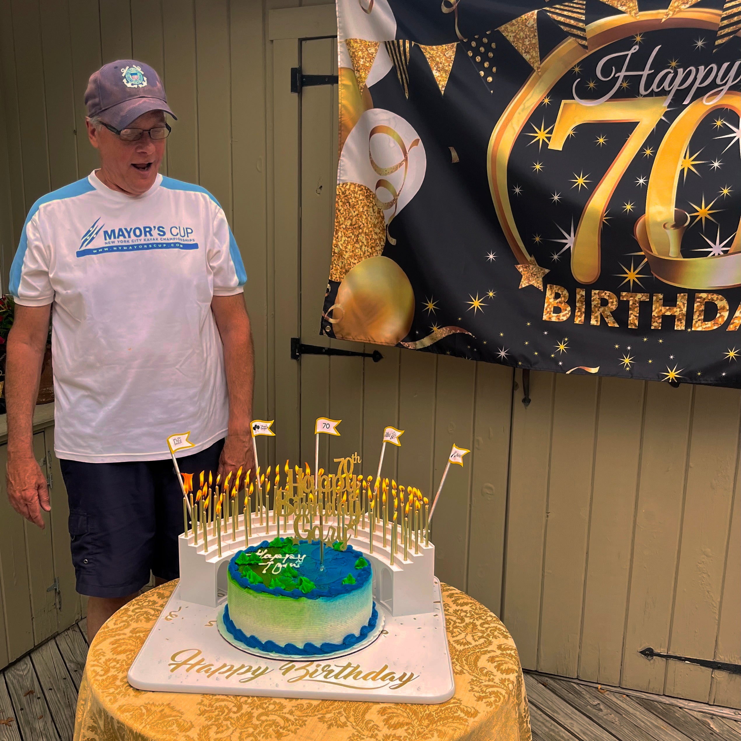 Outdoor 70th birthday surprise party with water-sports theme birthday cake.