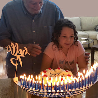 75th birthday party for grandfather and granddaughter about to blow out 75 candles