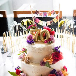 70th birthday cake in three tiers with decorated Celebration Stadium candle holder