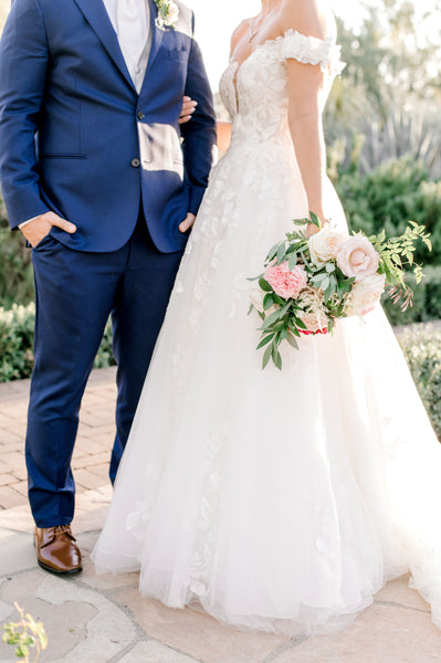 A bride and groom holding flowers at El Chorro Lodge in paradise valley