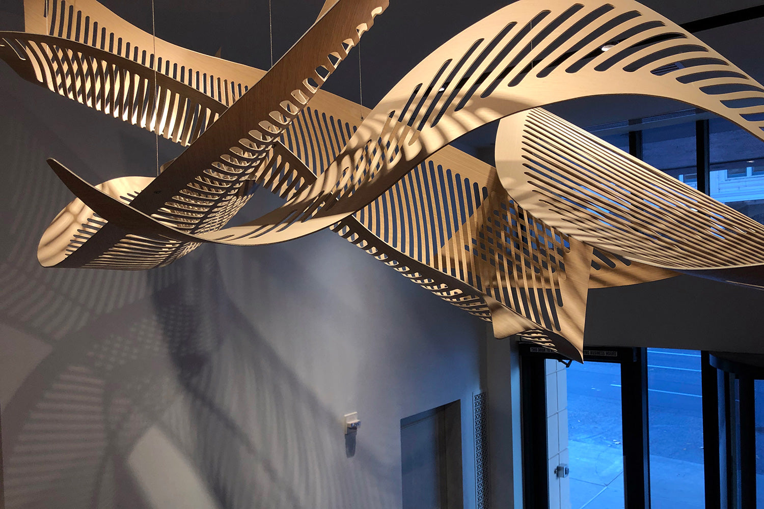 Twisted wood sculpture hanging from a ceiling