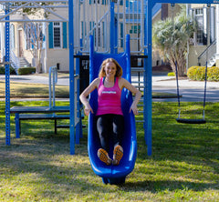 Adult woman sliding down slide on SwingSesh fitness playset