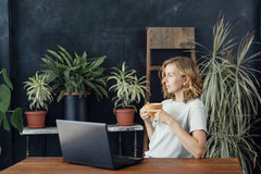 Woman sitting in front of dracaena's in her office
