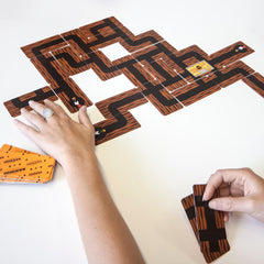 Image of Bandido cards laid out on table during a game with a hand placing one