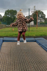 Girl jumping on public rectangular trampoline