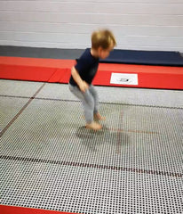 1.5 year old jumping on a rectangular trampoline in gymnastics class