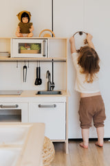 Child with toy kitchen