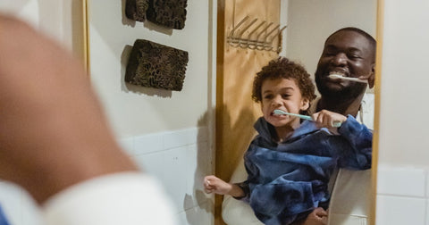 father and son brushing teeth