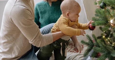 child decorating christmas tree