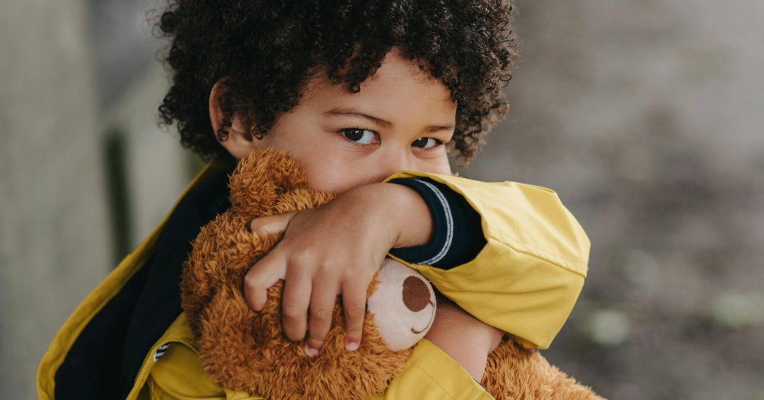 child hugging stuffed bear