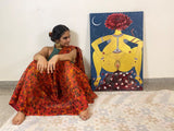 Photo of Lyla sitting in pose next to her piece Aadya Shakti.