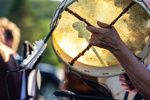 Native american hand drum with feather on sunny day