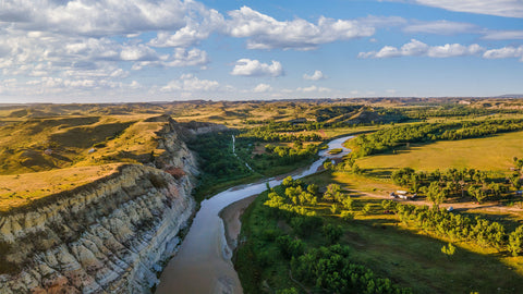 view of gorge and river during afternoon with clouds and blue skies