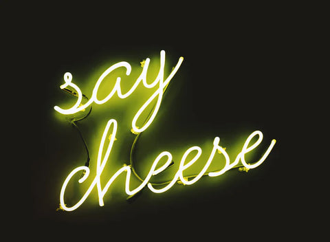 A neon sign that reads 'say cheese'.