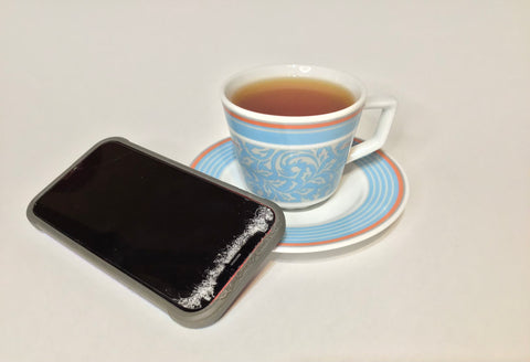 Rooibos tea in a blue cup and saucer next to a cell phone